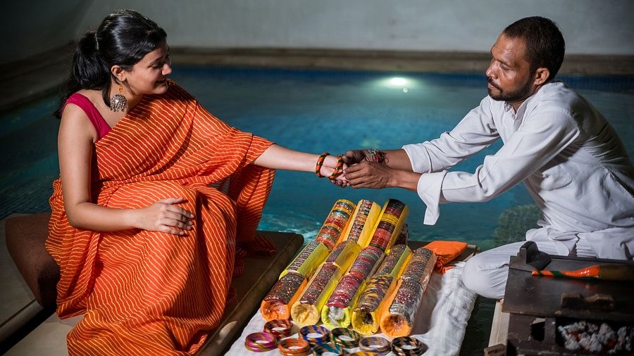 Guest experiencing traditional lac bangle-making by the poolside at Juna Mahal, Ranthambore.